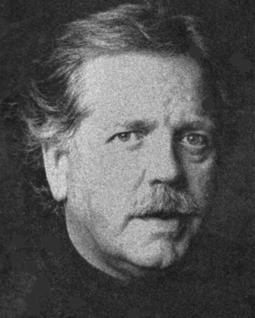 Black-and-white portrait of an older man with wavy hair, a mustache, and a serious expression, looking slightly to the side.