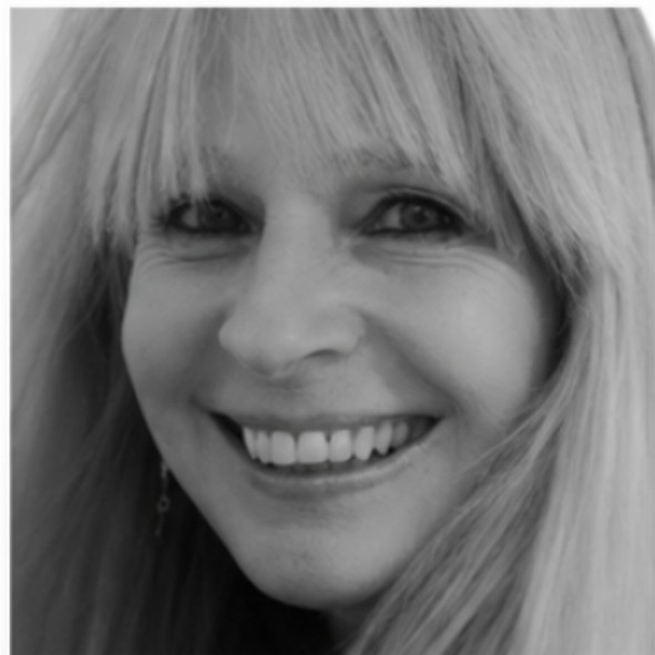 Black and white close-up photo of a woman with long, light-colored hair smiling warmly at the camera.