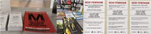 A display of museum magazines, books on shelves, and four posters titled "New Feminism" in multiple languages, announcing a discussion featuring Jana Ettlter, Leon Aeon, and Corinna Zelke.